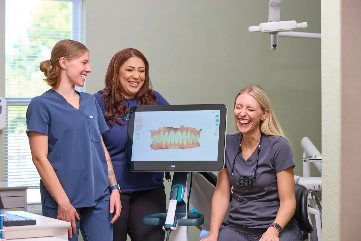 Dr. Cyndi Blalock and team smiling while using an iTero digital scanner for comfortable dental impressions in St. Peters MO