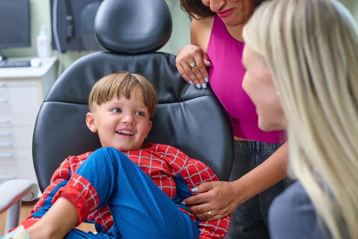 A young boy in a Spider-Man costume laughing during a fun and stress-free pediatric dental visit at Cardinal Dental in St. Peters, MO