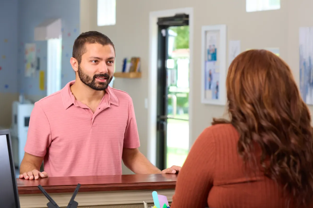 The friendly receptionist at Cardinal Dental of St. Peters welcomes a patient