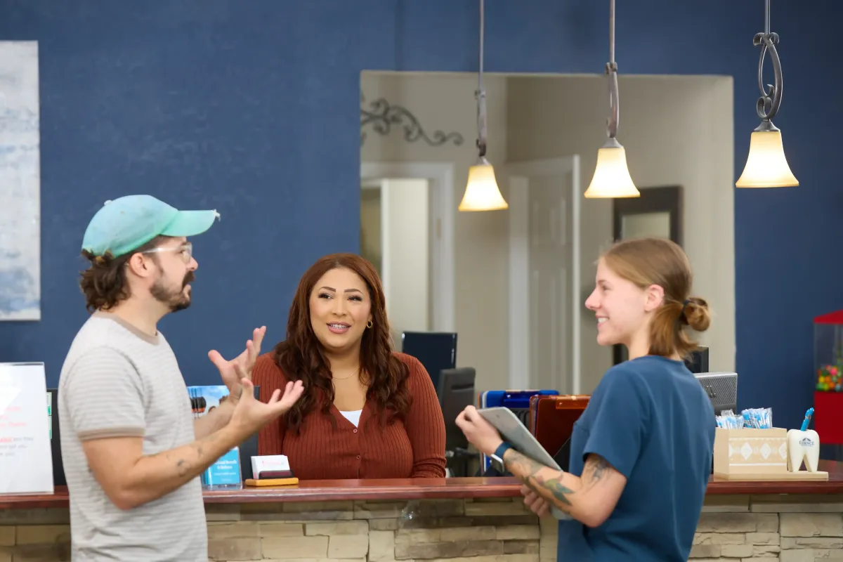 Dr. Cyndi Blalock welcoming patients at the Cardinal Dental front desk in St. Peters MO
