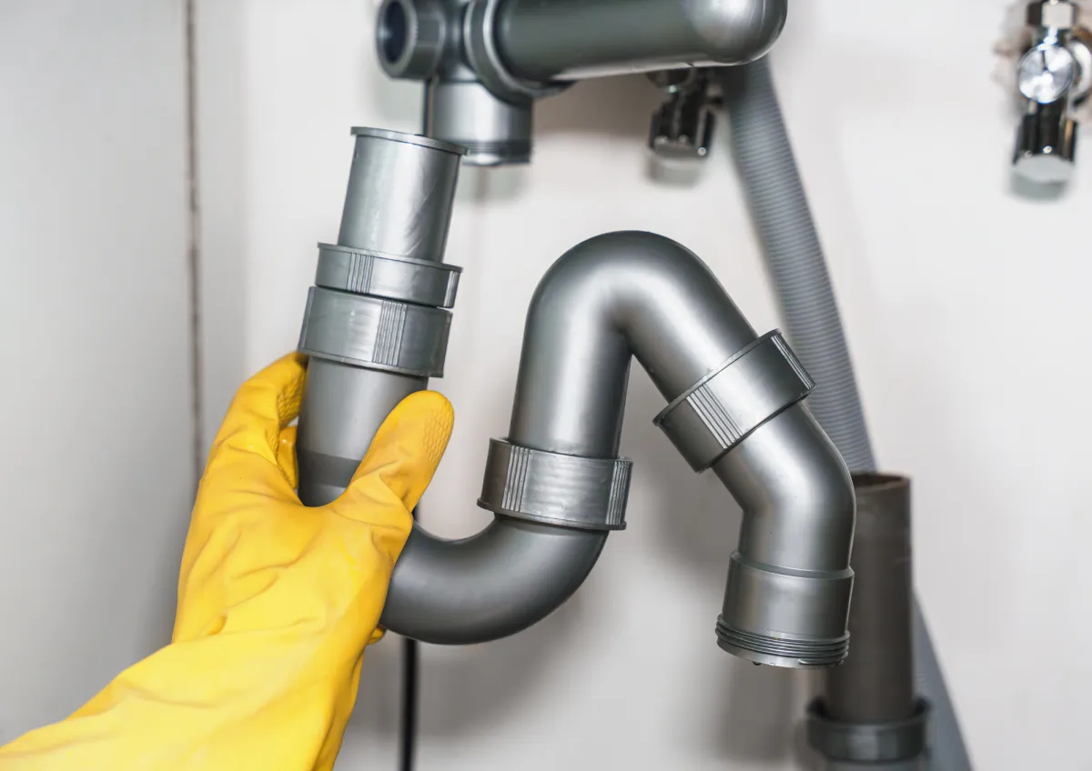 Plumber inspecting and cleaning a residential drain pipe