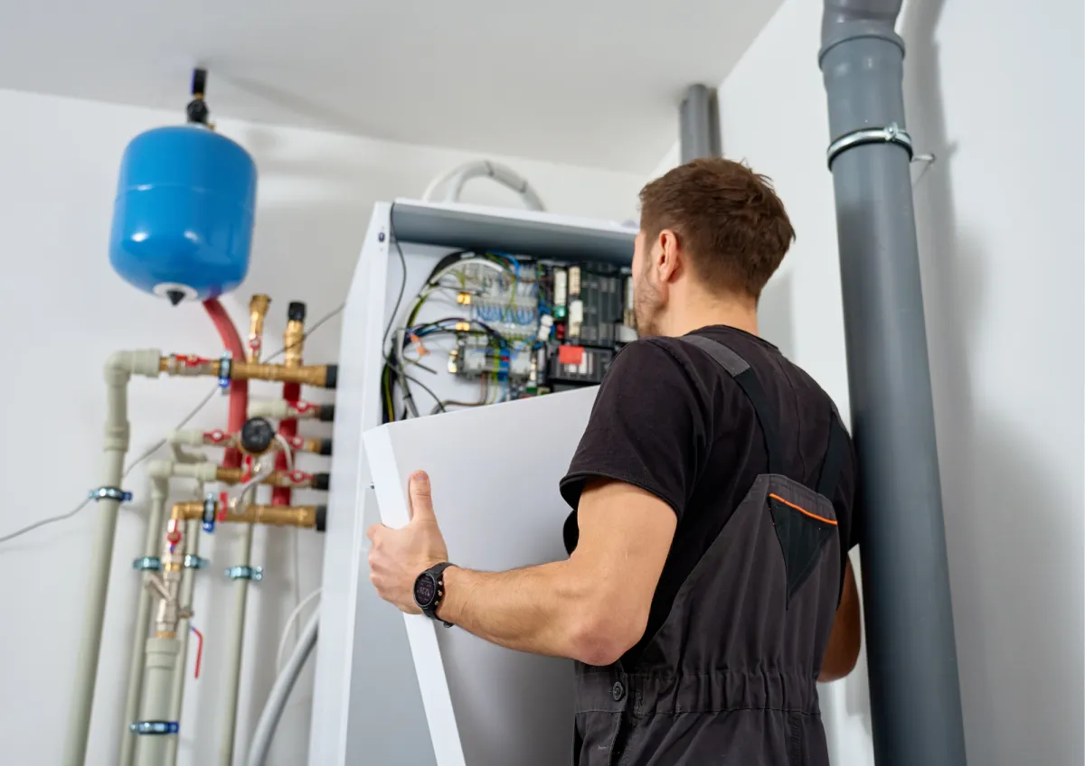 Plumber servicing a residential heating system and water heater