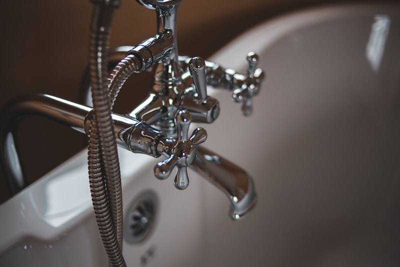 Close-up of chrome bathroom sink faucet and plumbing fixture
