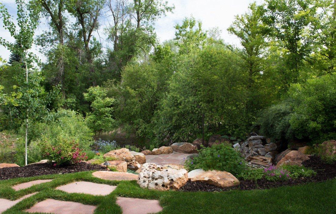 Image of outdoor garden landscape with trees mulch pavers rocks and flowers and shrubs