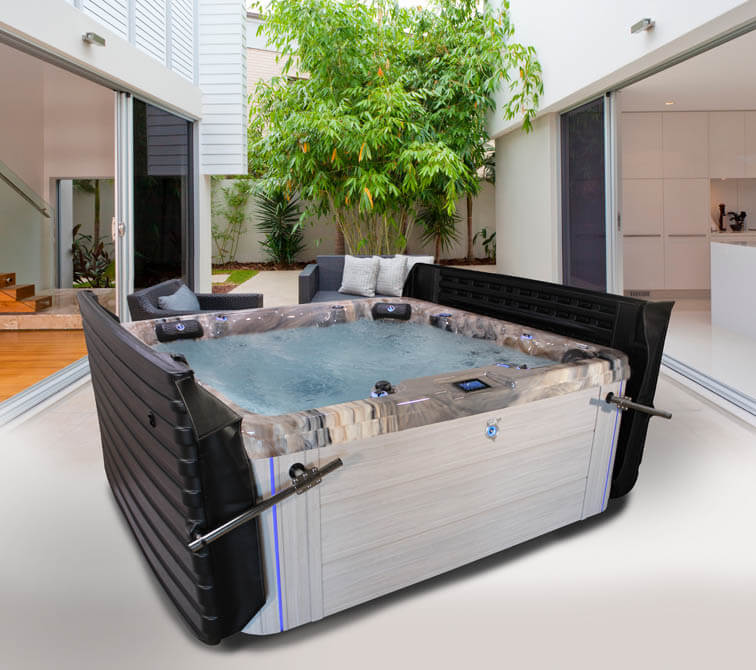 Indoor swimming pool with lounge chairs and large windows.