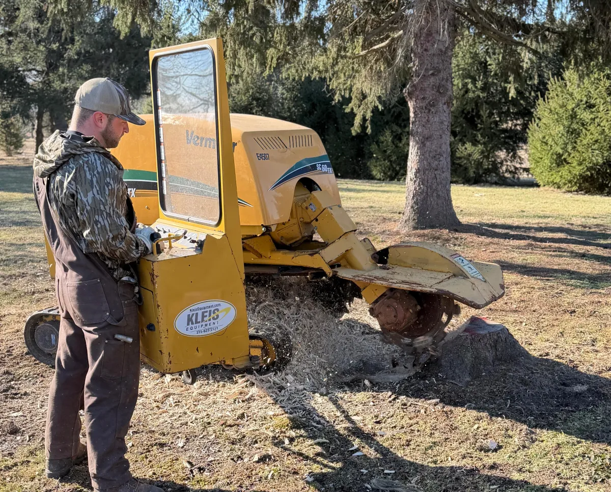 A large stump with a machine nearby, likely performing stump grinding or removal.