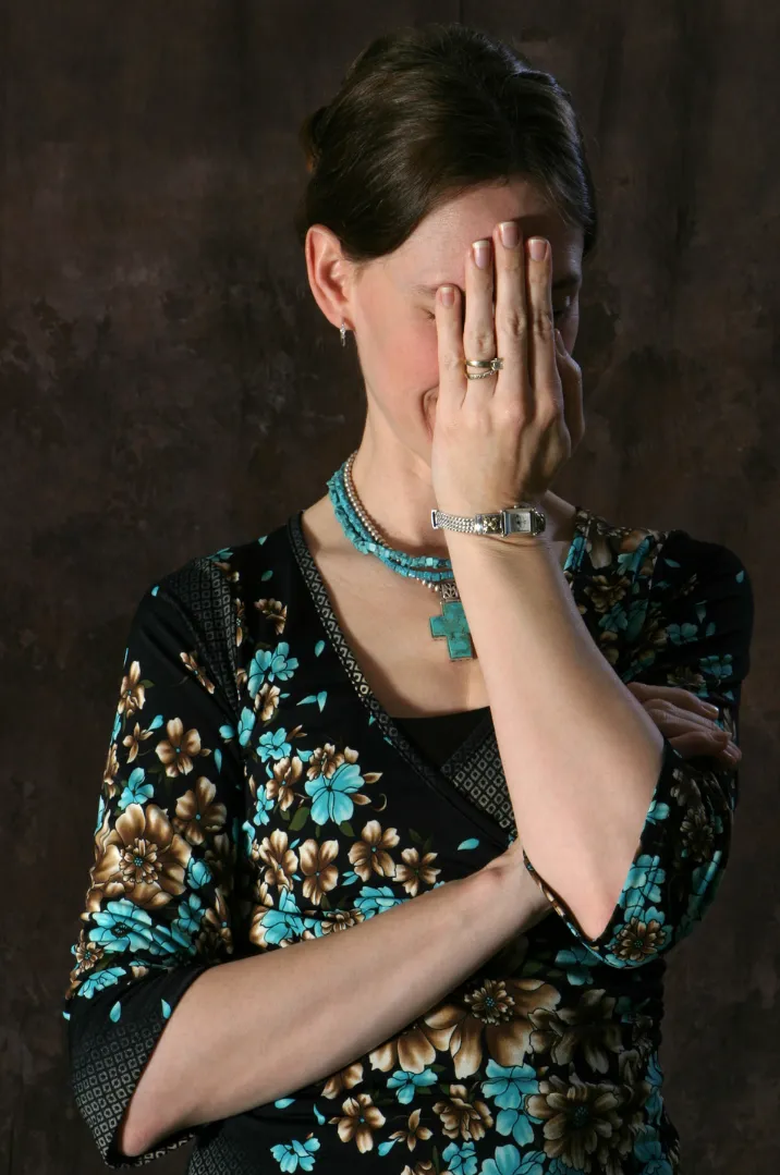 Embarrassed Woman covering face with hand