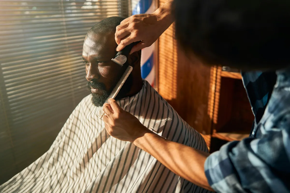 barber giving client a beard trim
