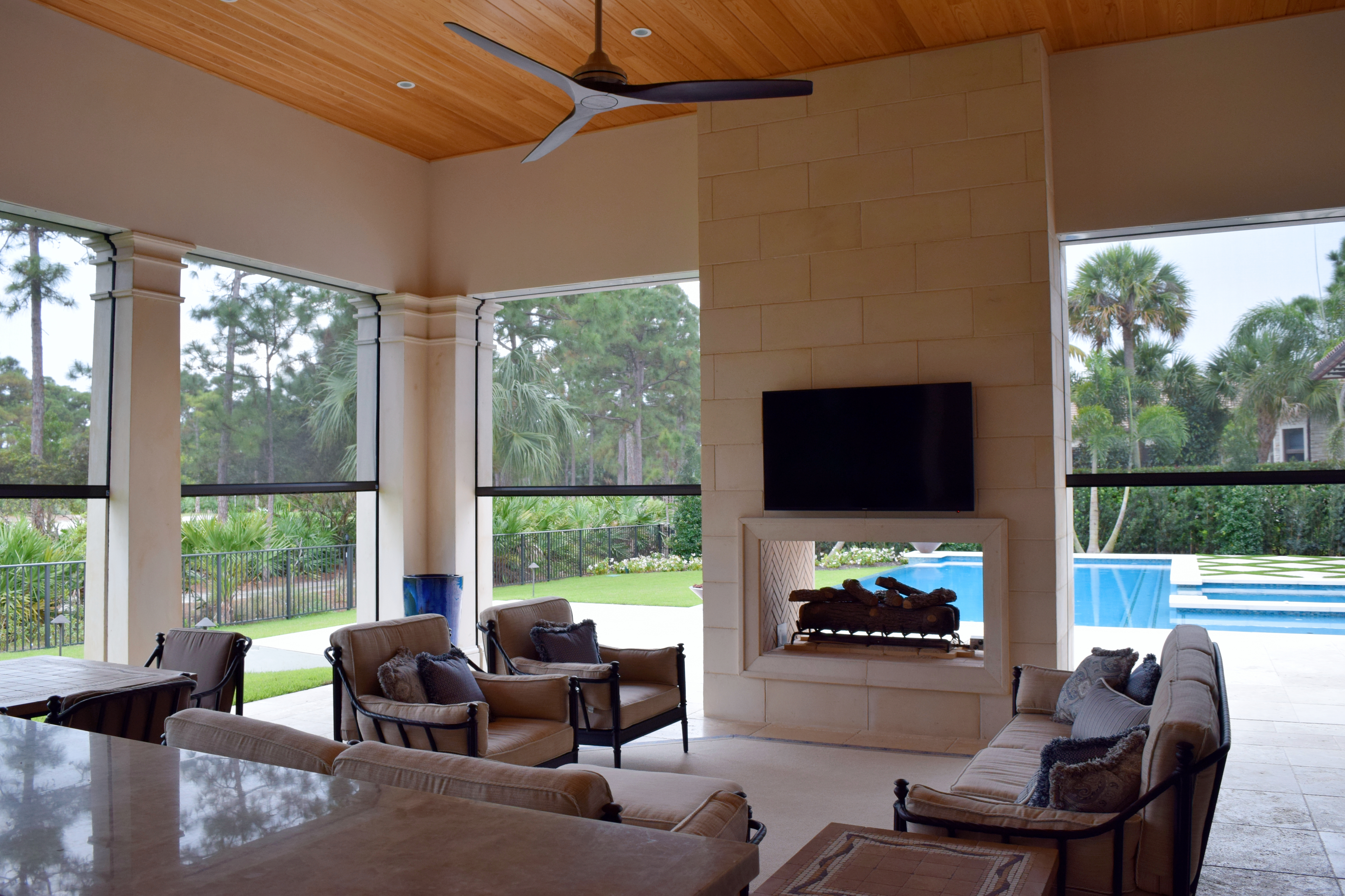 Motorized screens in an enclosed screened in porch with a fireplace