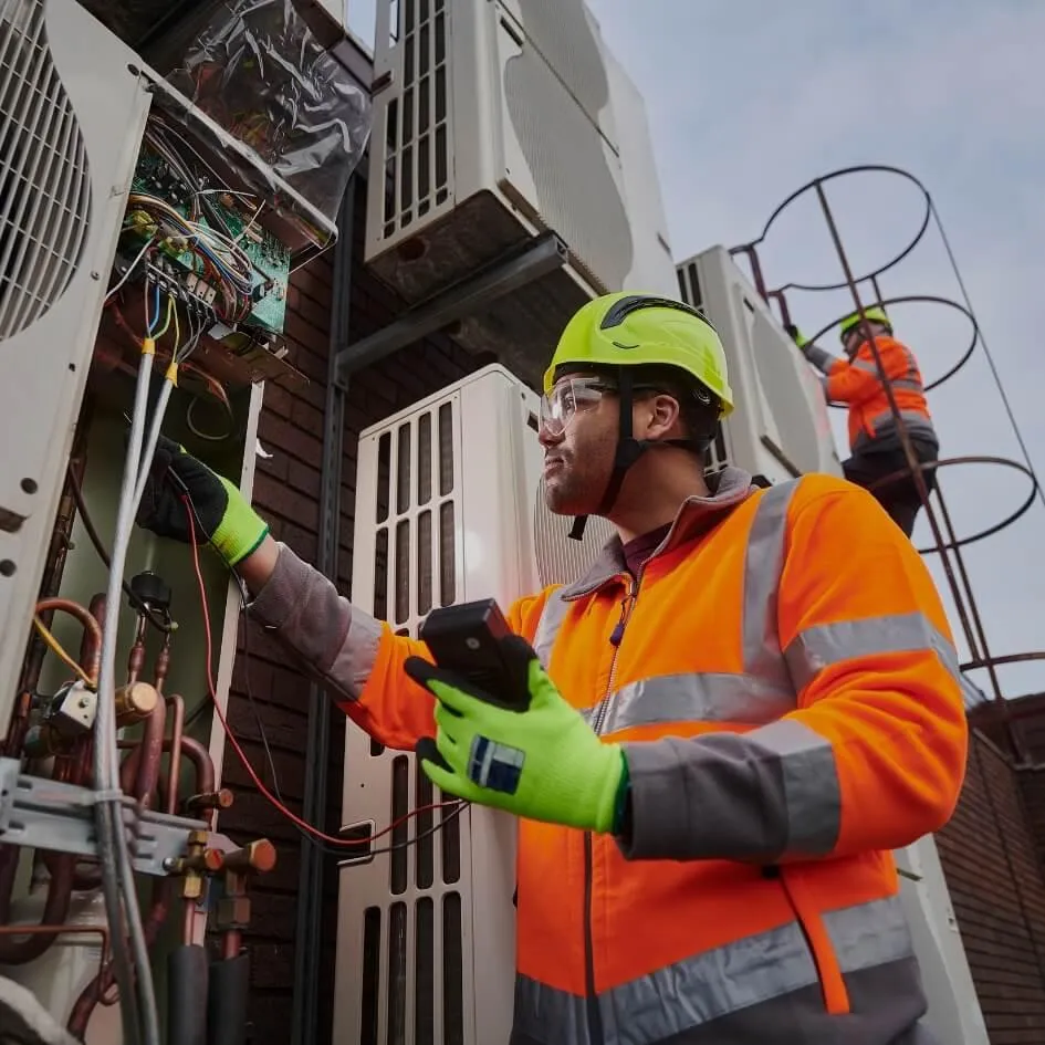 Stock photo of contractors inspecting HVAC exhaust and electrical wiring – representing CU Solutions’ expert HVAC and electrical services in Denver