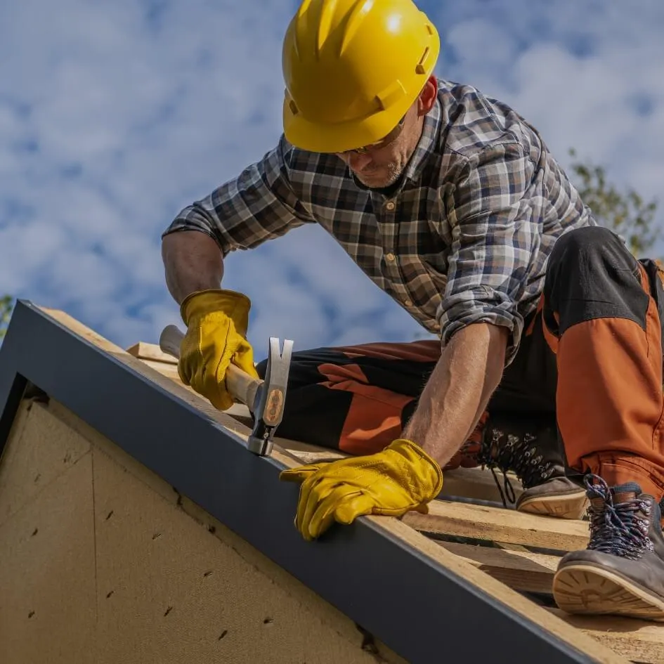 Stock photo of roofing contractor in hard hat working on a roof – symbolizing CU Solutions’ trusted Denver roofing repair and installation services