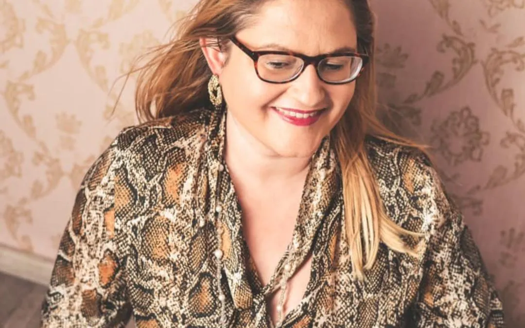 Eleni Iatridi smiling warmly in a snake-print top