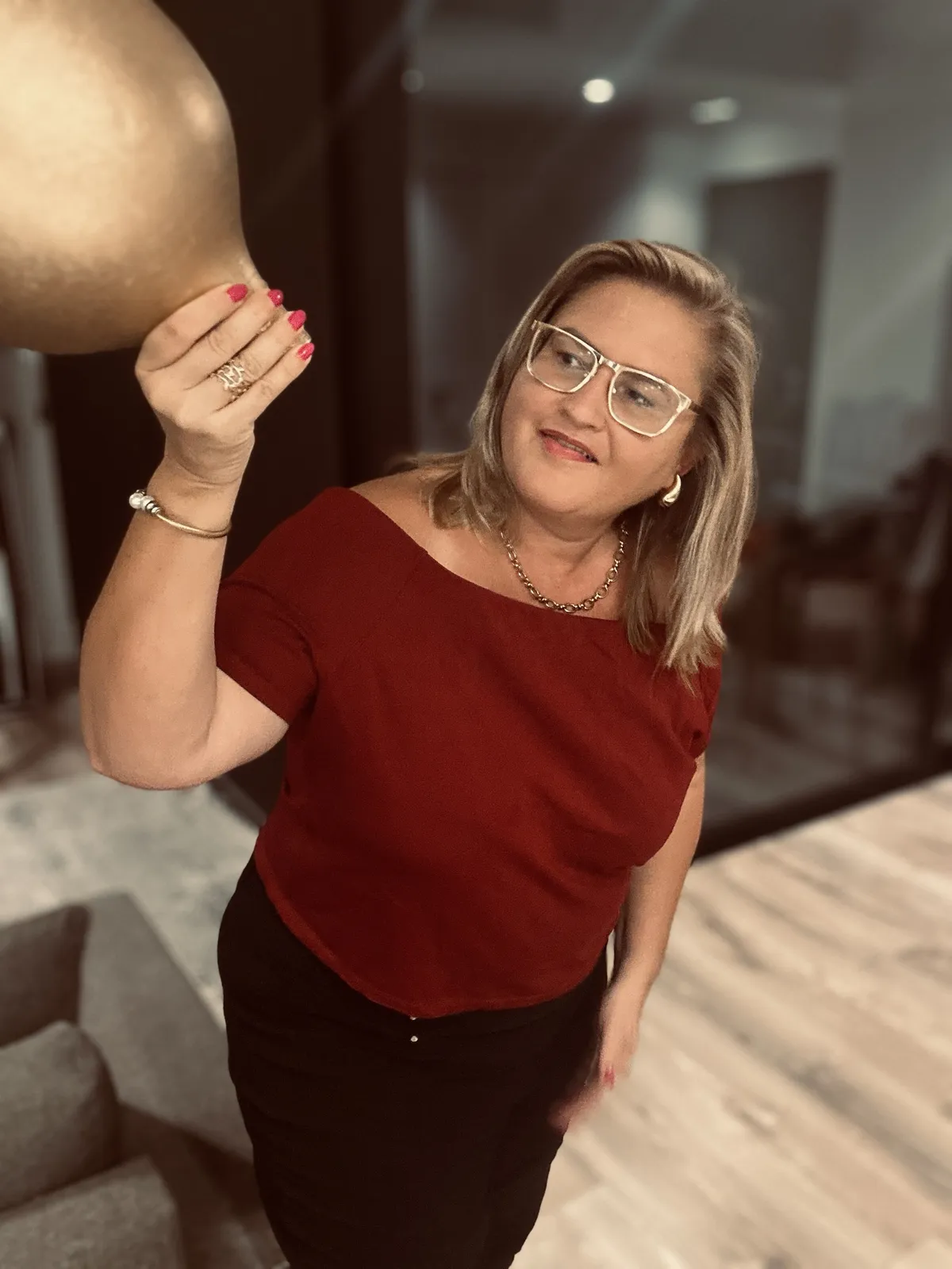 Eleni Iatridi in a red top, holding a golden vase