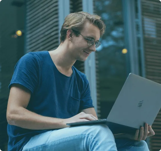 Young professional working remotely on a laptop in an outdoor setting.