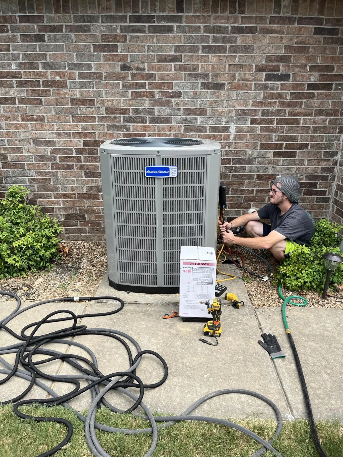 AC repair technician servicing air conditioning unit in Northwest Arkansas