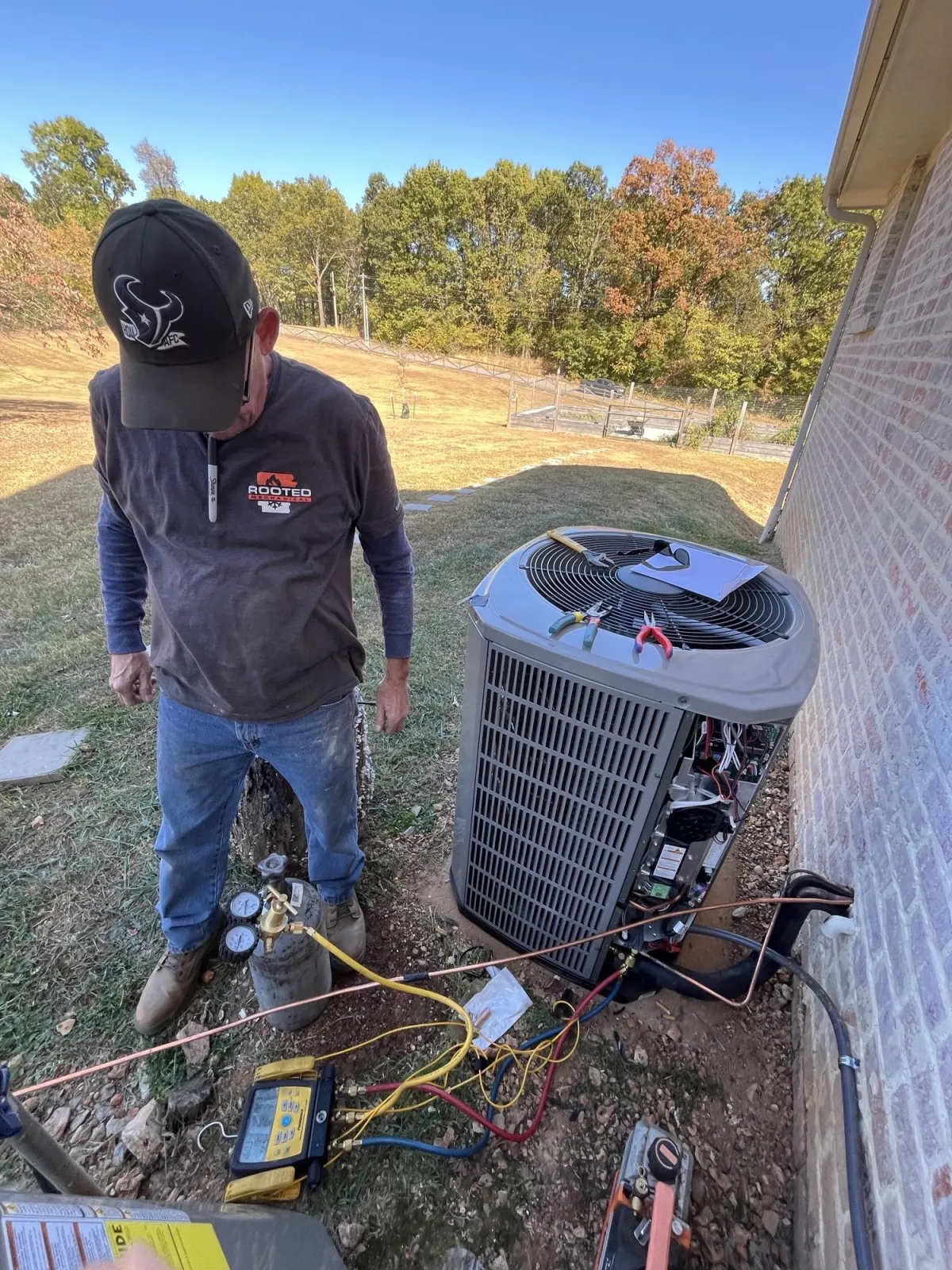 HVAC technician performing AC repair on residential system in Northwest Arkansas