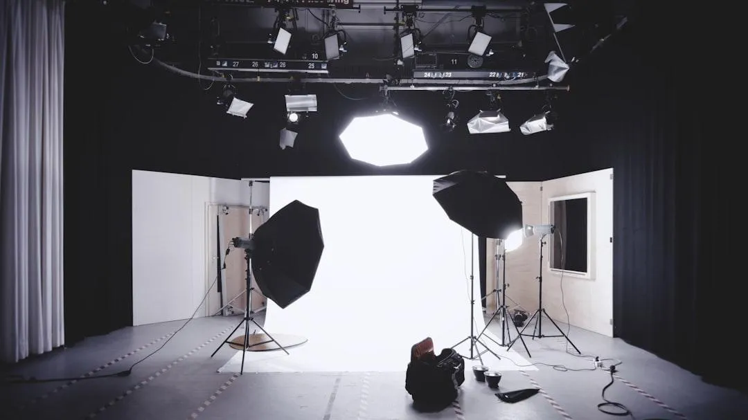 A mid-career photographer in a studio, adjusting lighting equipment, surrounded by backdrops and props, confident and creative, 1:1 aspect ratio