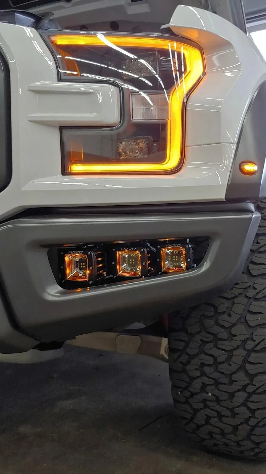 RidgeCraft Boltline cap installed on a rugged pickup parked at sunset on a gravel boat launch. Warm dusk sky, subtle sea spray in background, photorealistic composition emphasizing fit, clamp detail, and textured finish — lifestyle context for product use.