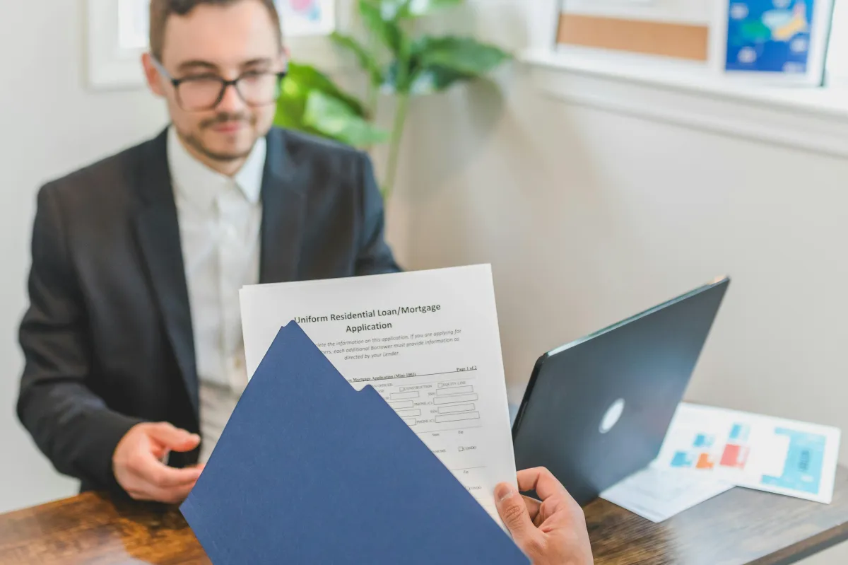 Business owner reviewing financial documents and loan agreements in an office