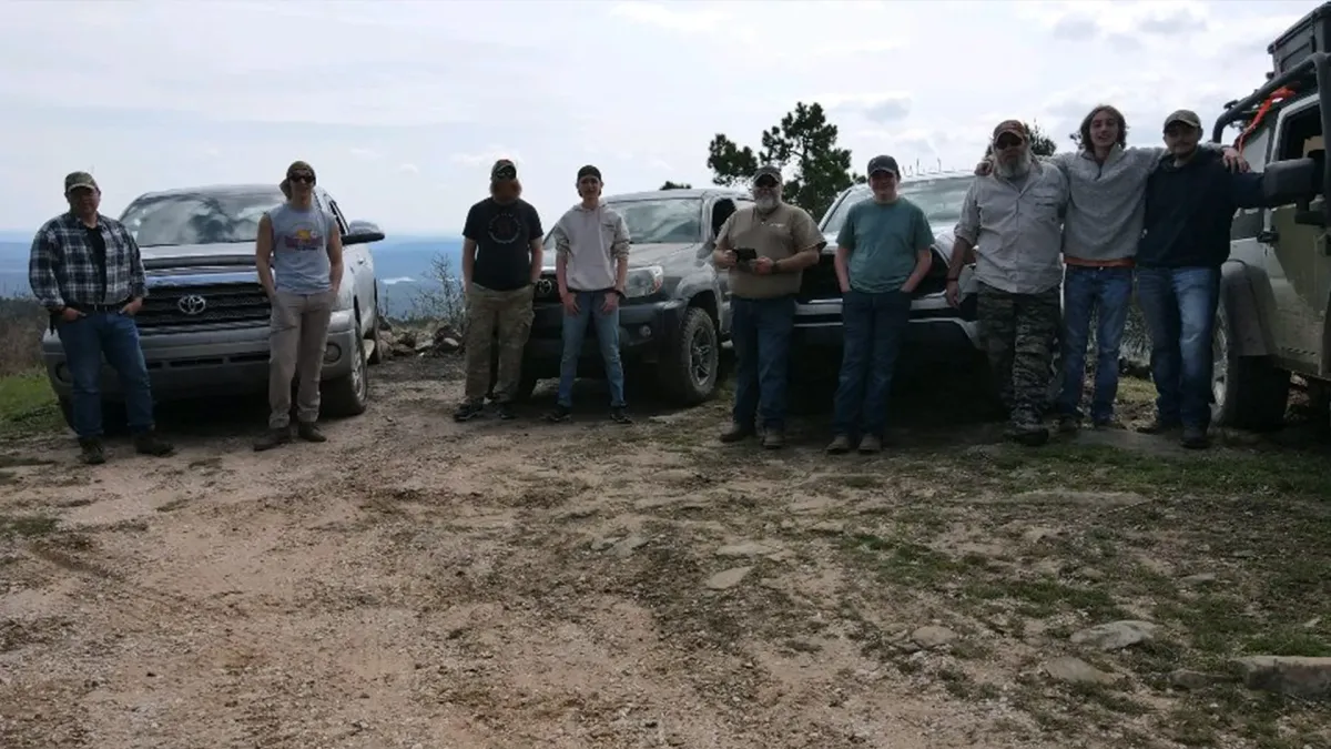ManAlive Overlanding - Men Standing In Front of Their Trucks on Top of a Mountain