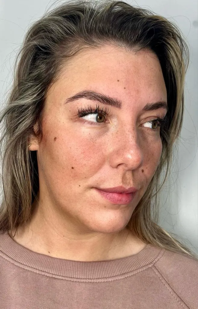 A women showing off her eyebrows after microblading treatment. 