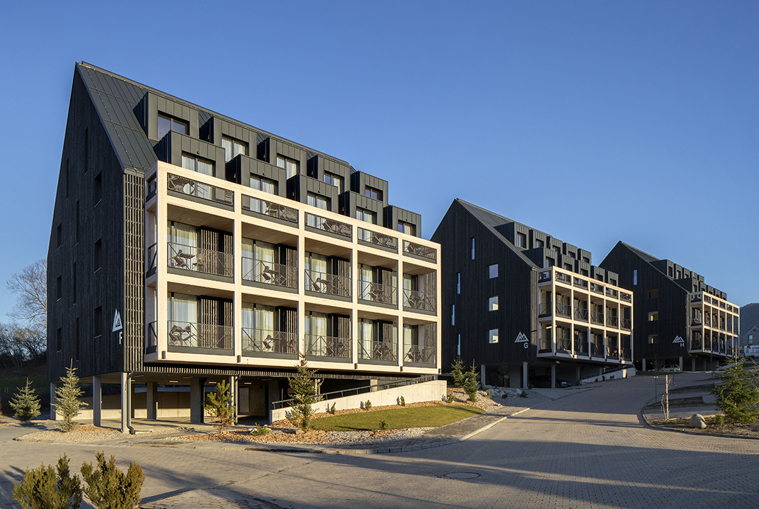 Moderná hotelová izba s dreveným čelom postele