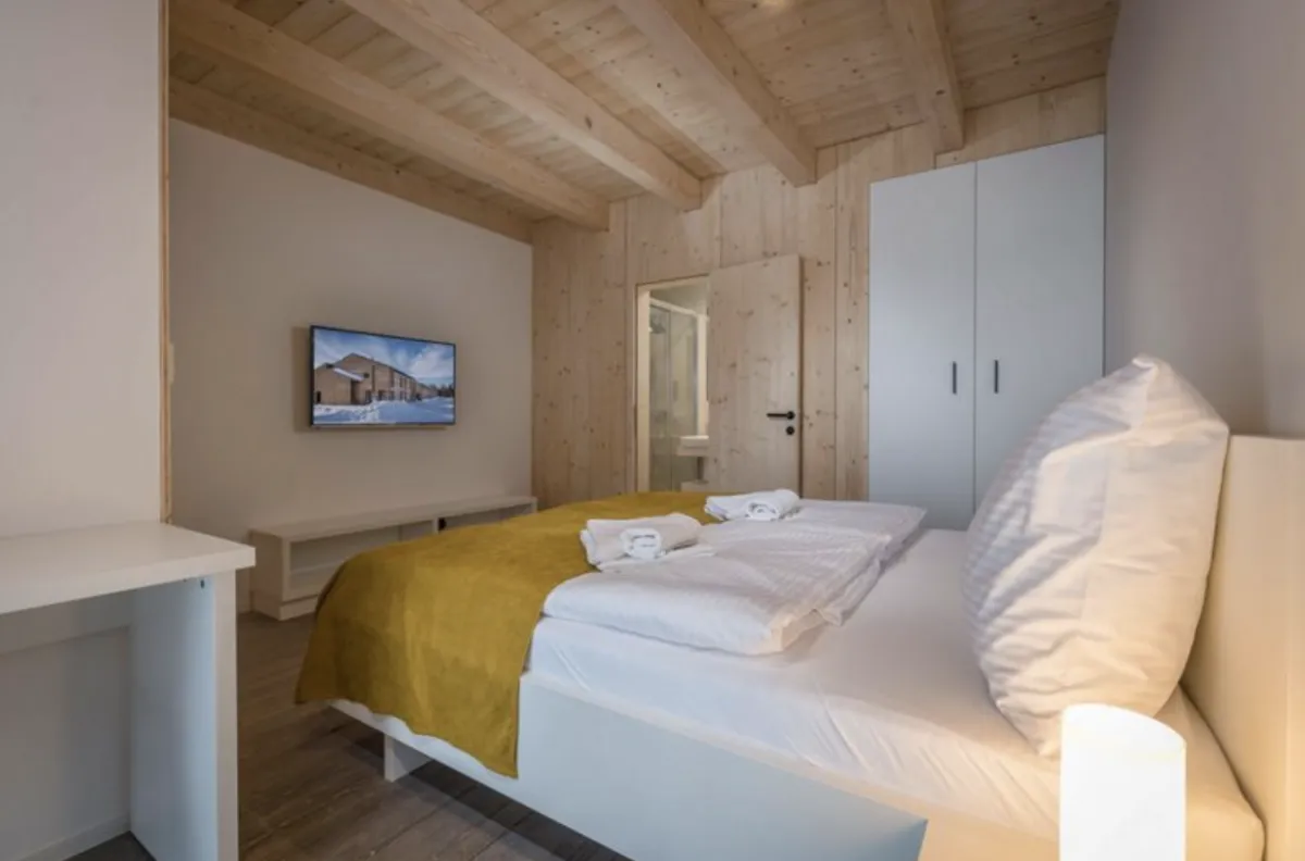 Moderná hotelová izba s dreveným čelom postele