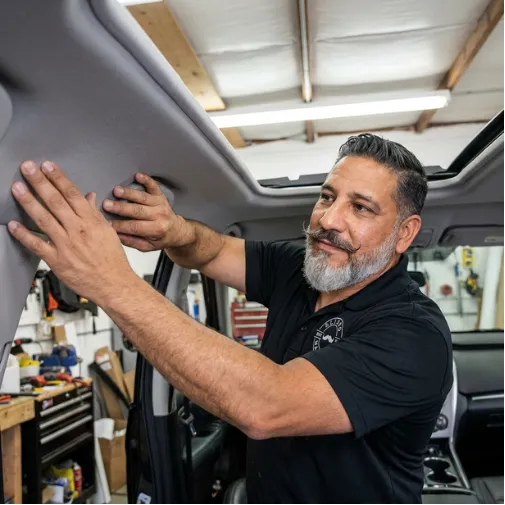 Auto upholstery technician installing a new car headliner by EM Upholstery Technology