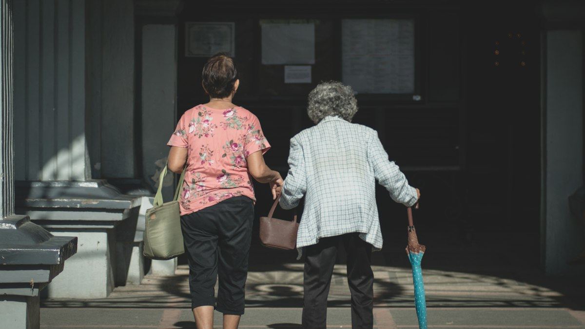 Adult daughter walking alongside her elderly mother while planning the next step in senior care near South Elgin