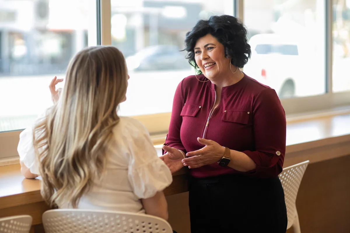 Two women engage in a conversation at a cafe