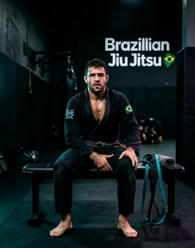 BJJ fighter in black gi holding his knee during training rehabilitation