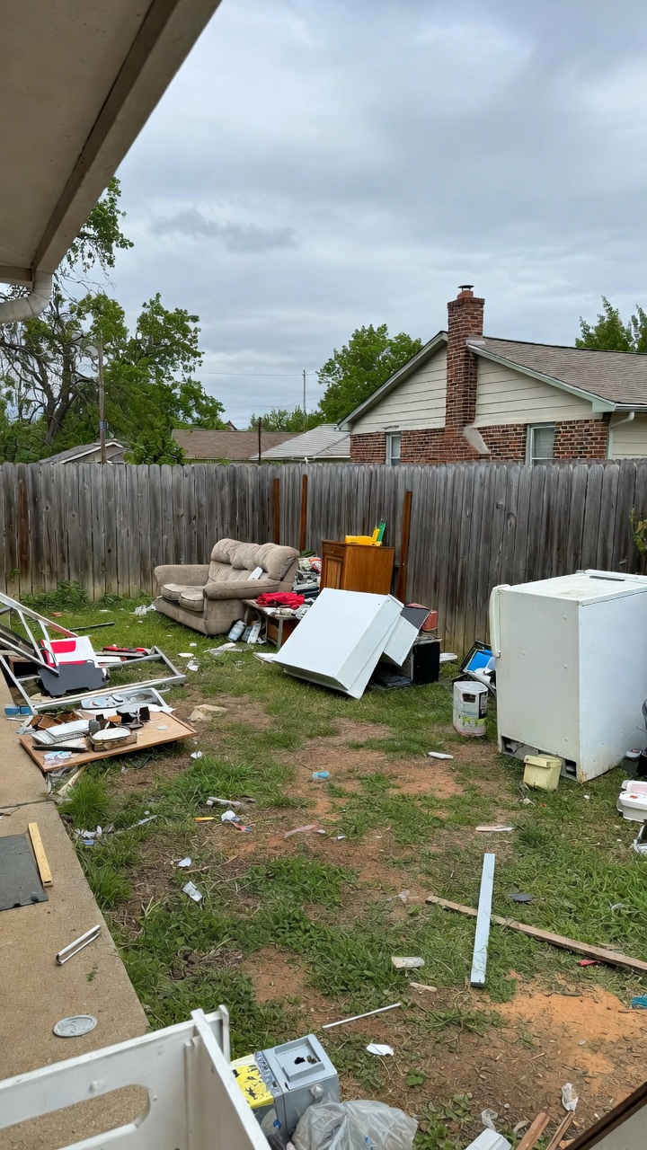 Backyard with scattered debris and old appliances before junk removal in Springdale, AR