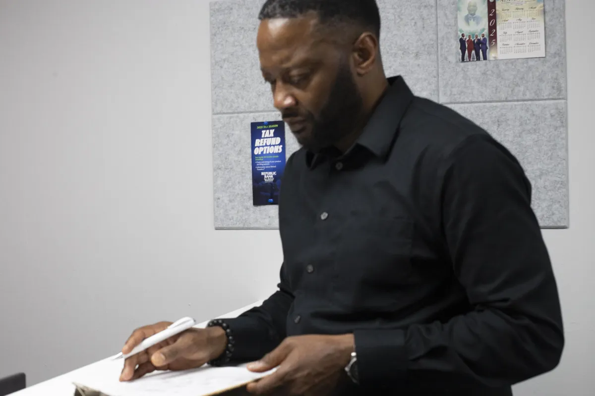 man writing on paper