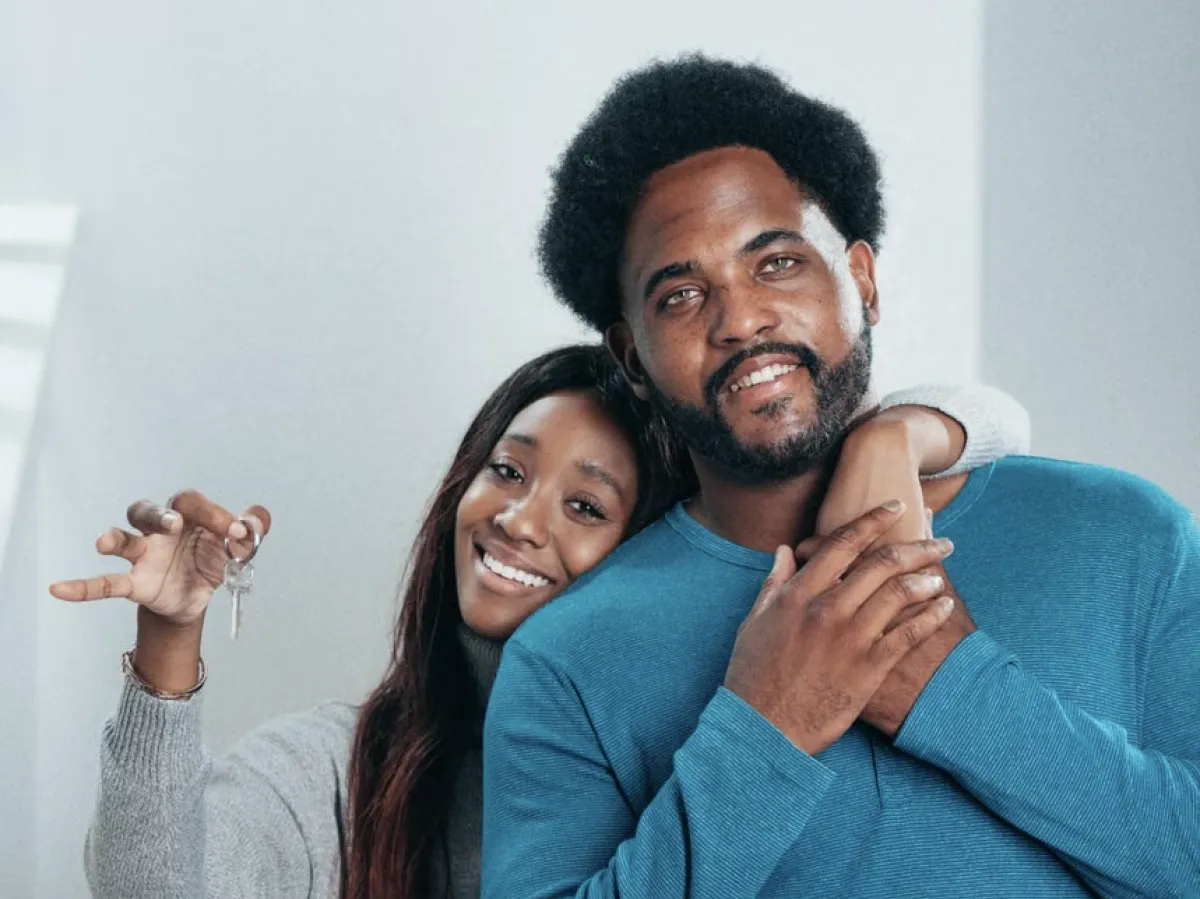 first time home buyer family holding keys in front of new home