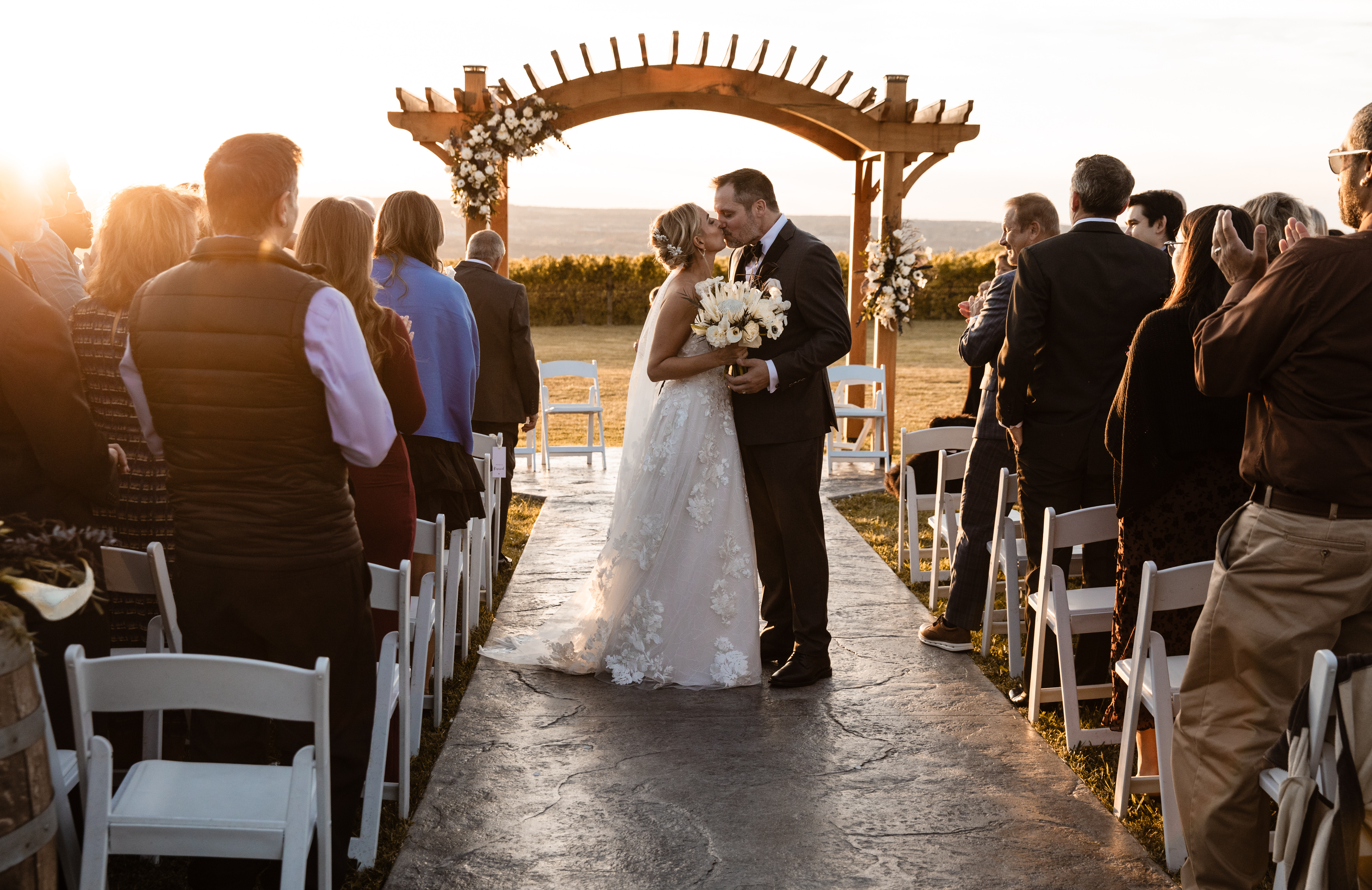 couple holding hands while standing near tree barks