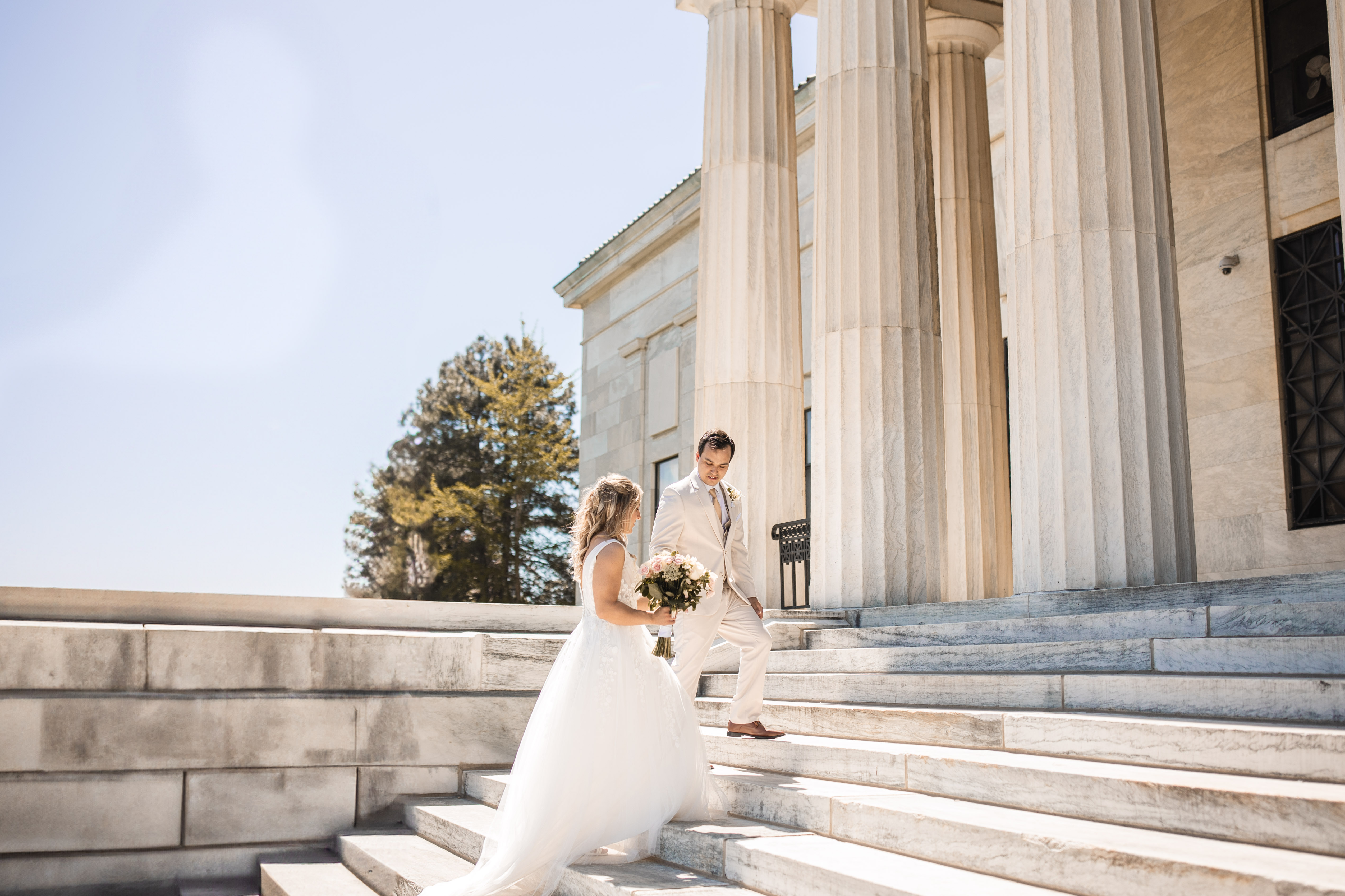 A wedding party on a balcony inside a grand building.