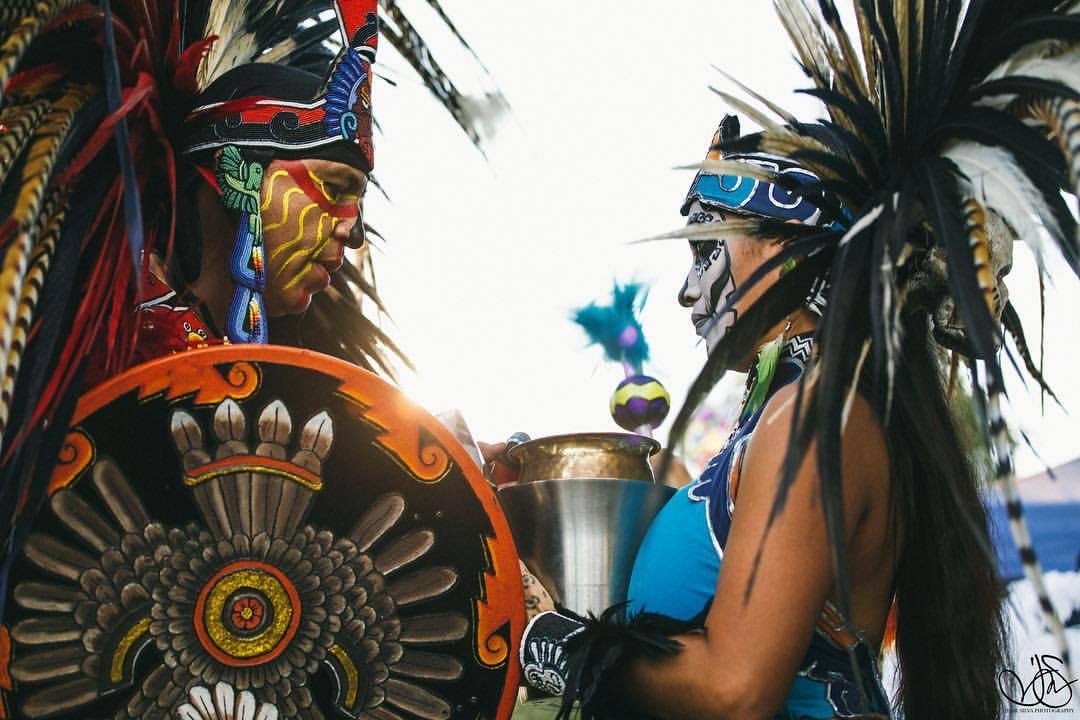 Danzantes beside a blue lowrider