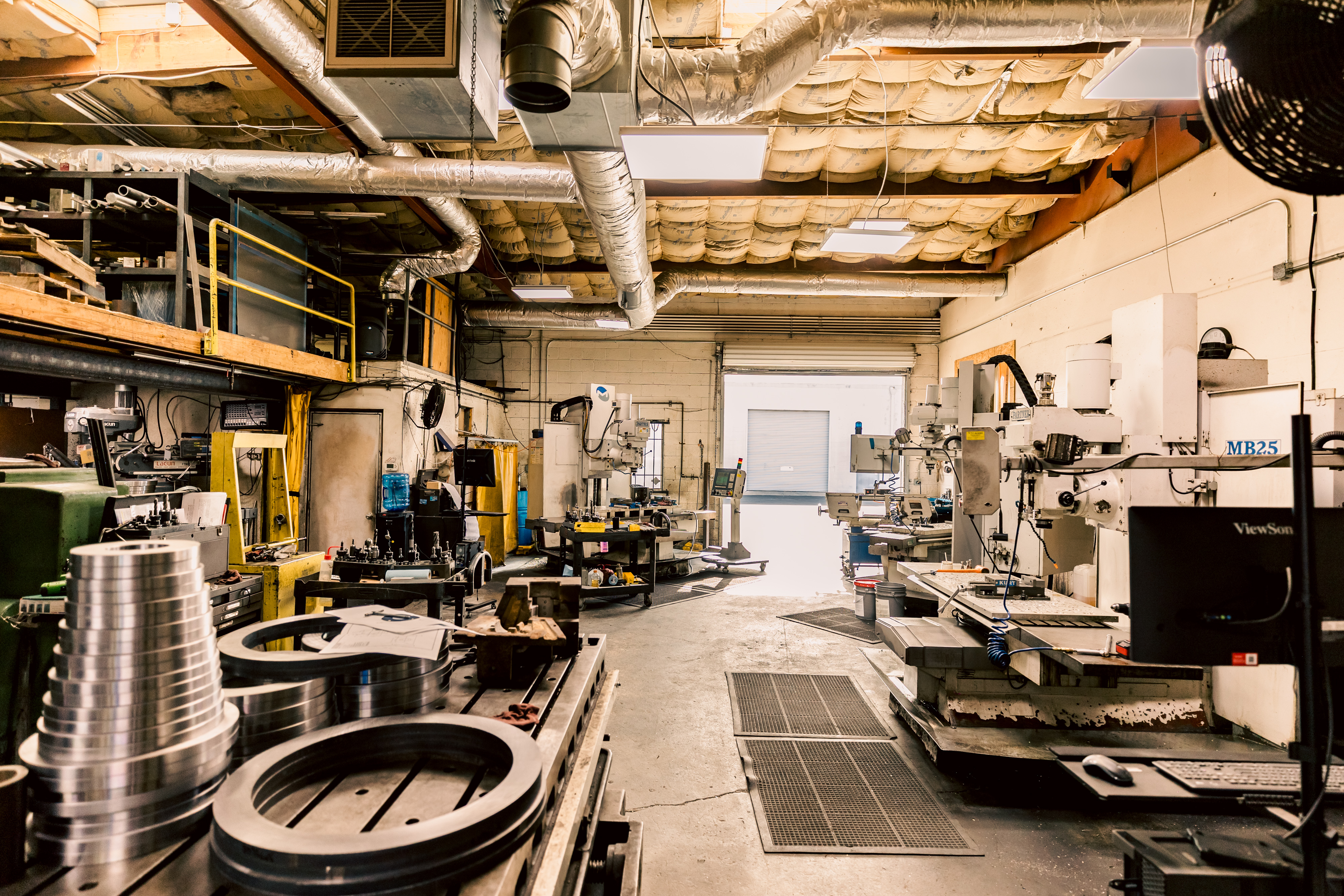 A wide shot of the Toolroom Milling Department showing several machines and components in a well-lit machine shop.