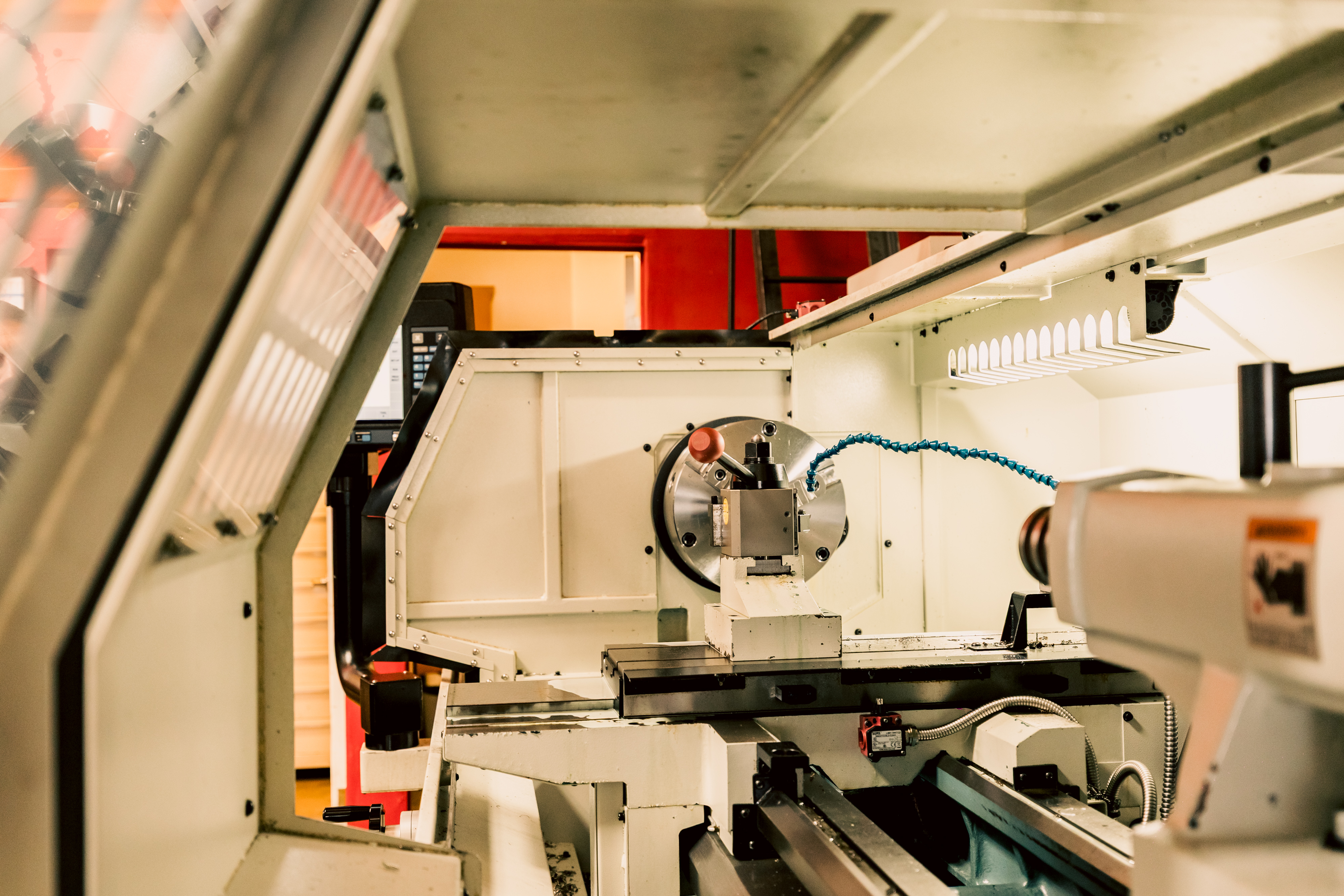 A close-up of the internal components and chuck of a Prototrak 2470 Toolroom Lathe in a machine shop.