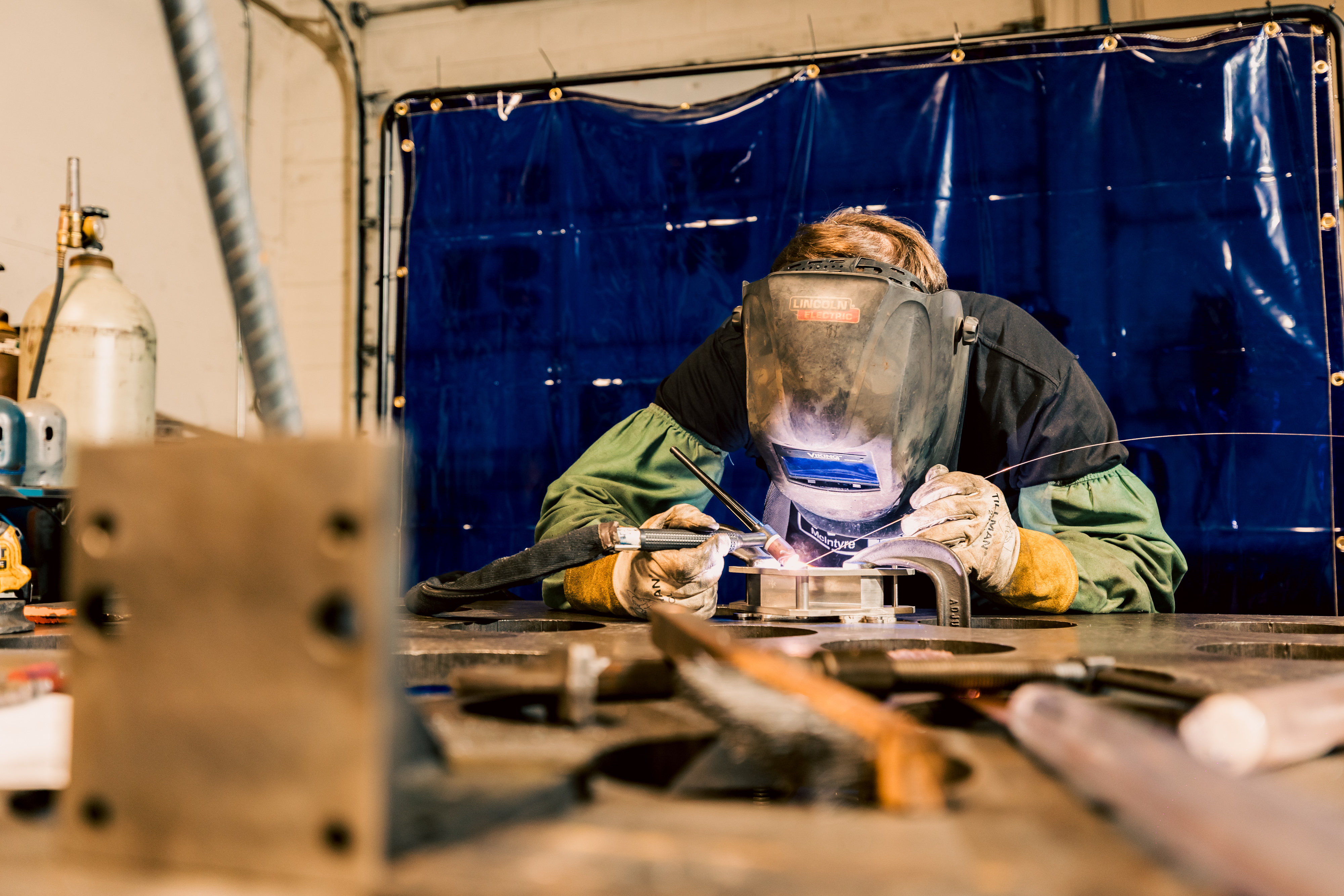 A precision TIG welding operation on a custom fabricated tooling component at McIntyre Tool & Machine.