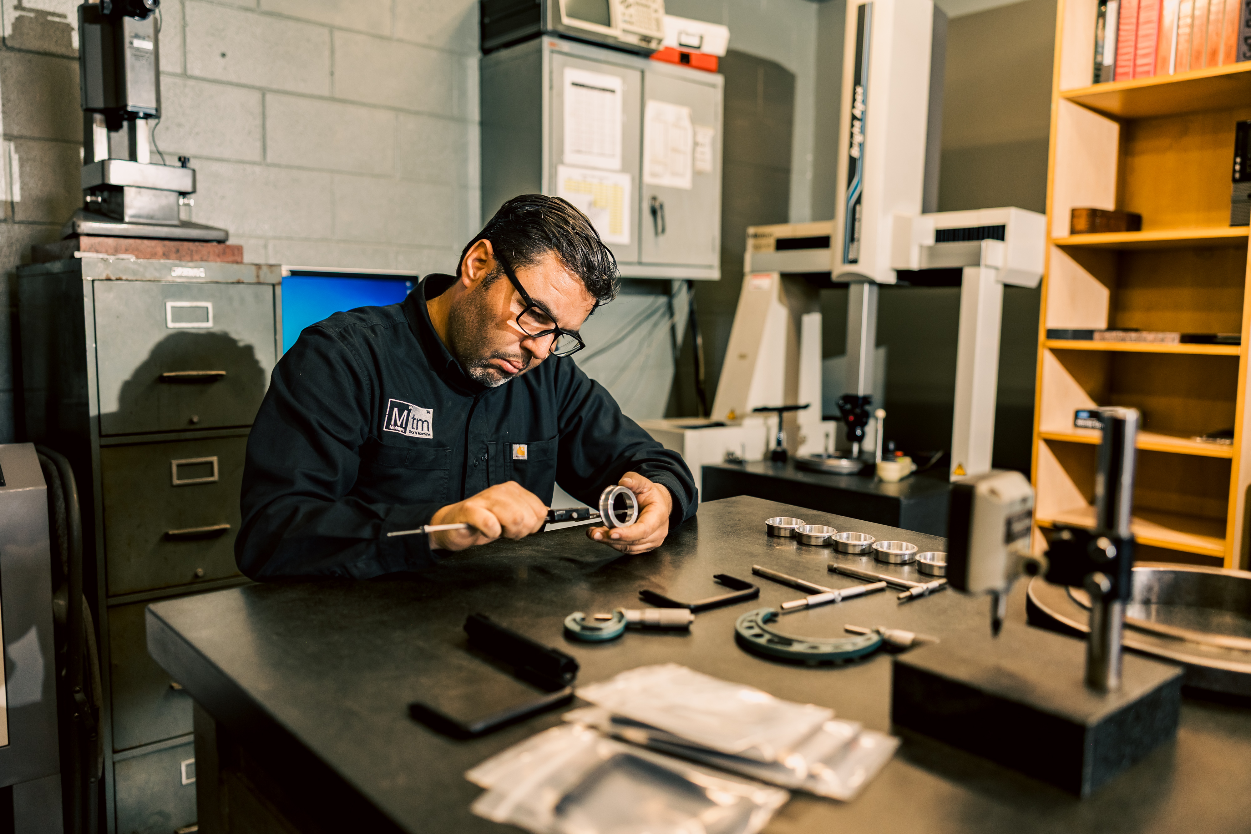 Pedro qualifying production parts in the MTM Inspection department using precision tools.