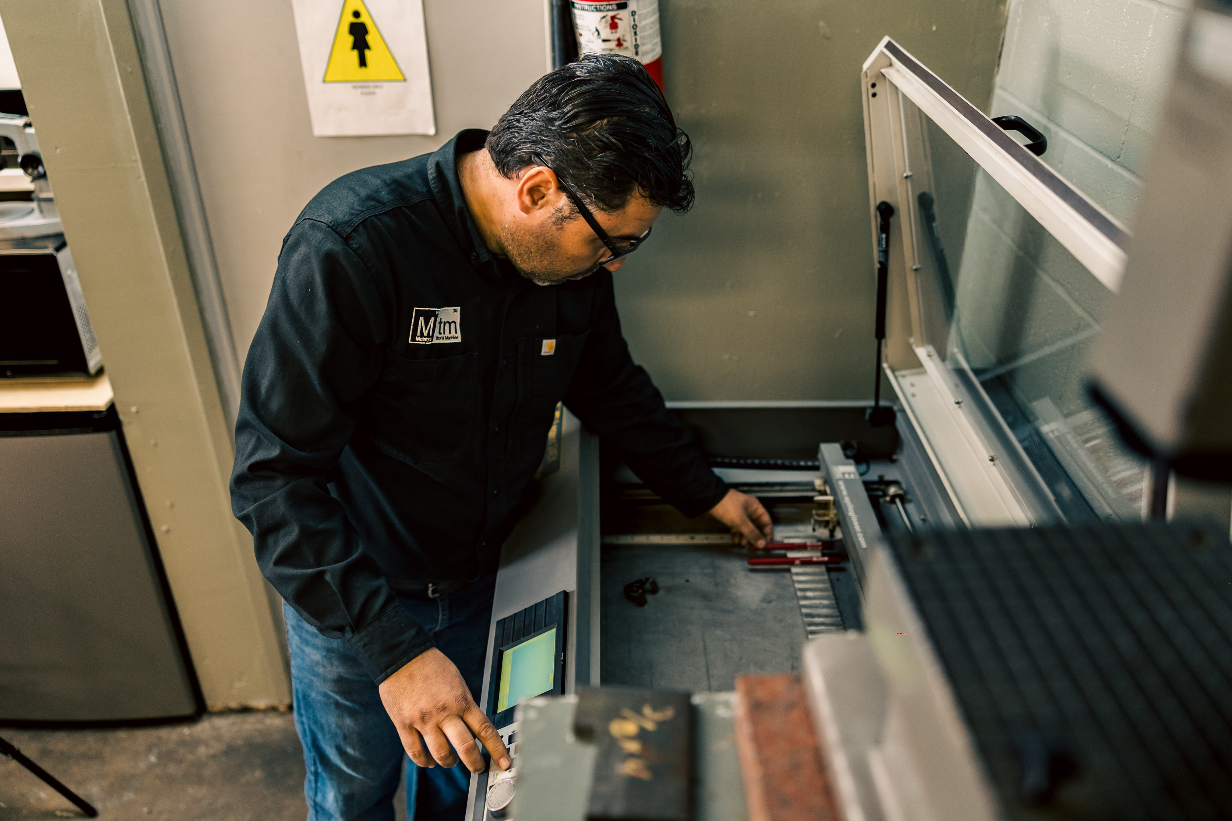 Overseeing a precision laser engraving and part marking process in the workshop.