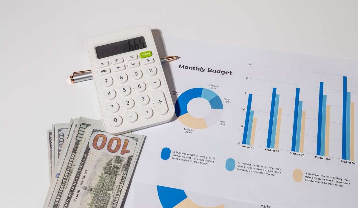 A close-up of two hands, one older and one younger, gently clasped over a table with soft natural light, symbolizing intergenerational support and community care. The background is softly blurred in warm neutral tones.