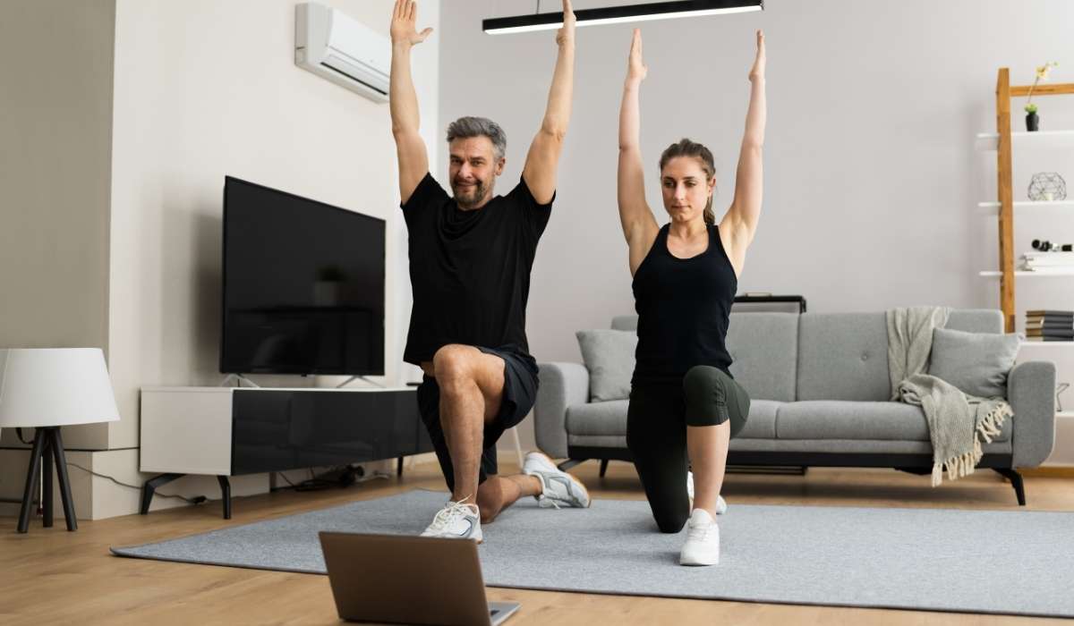 A close-up of two hands, one older and one younger, gently clasped over a table with soft natural light, symbolizing intergenerational support and community care. The background is softly blurred in warm neutral tones.