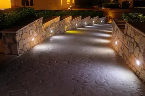 Outdoor landscape lighting along stone walkway by Desert Bloom Landscaping