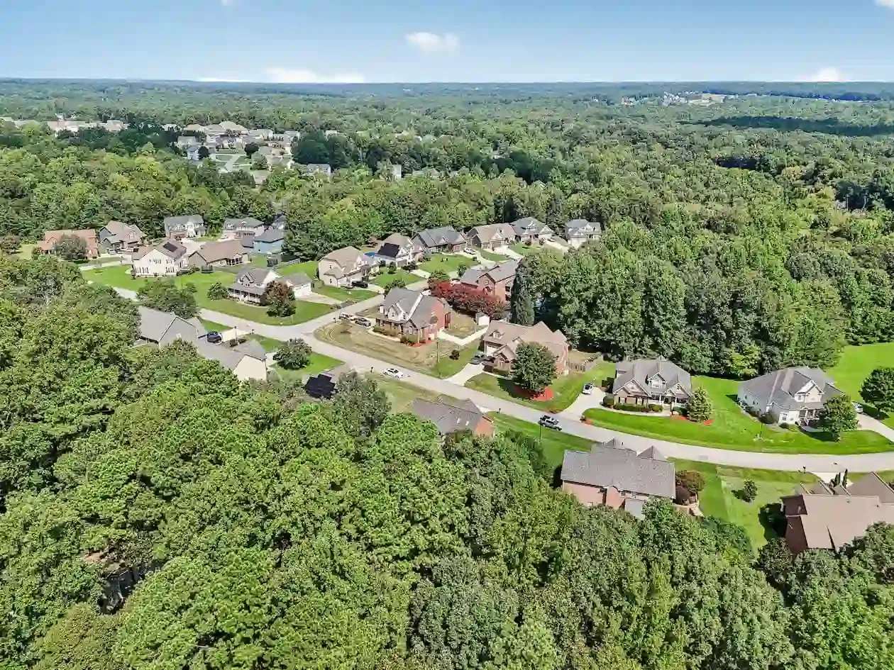 Aerial drone view of Clayton NC residential neighborhoods showing established homes mature tree canopy and community scale Johnston County