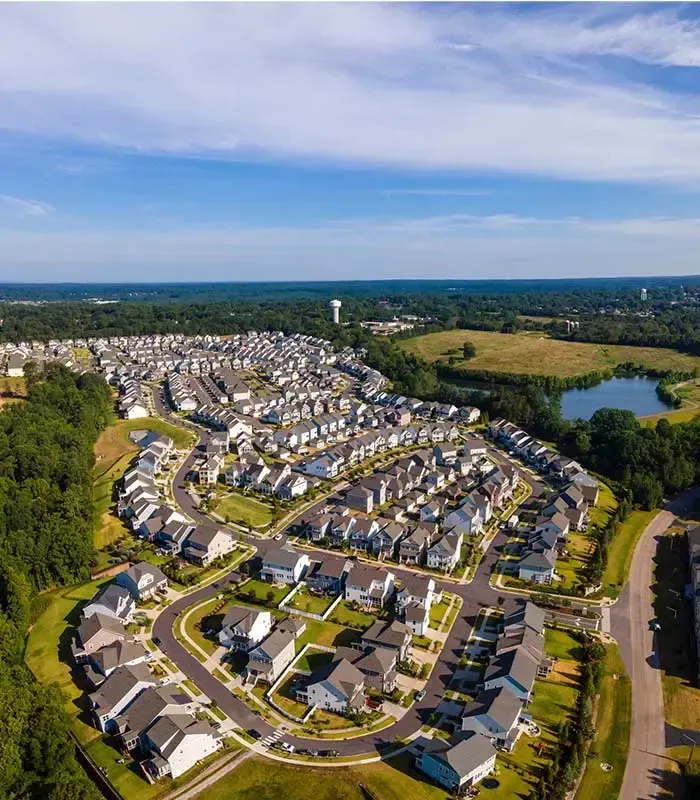 Aerial drone view of established Wake Forest NC neighborhood showing houses pond Wake County