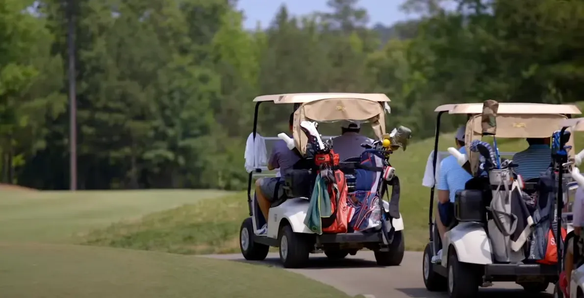 People in golf carts plaing golf at 12 Oaks in Holly Spings NC