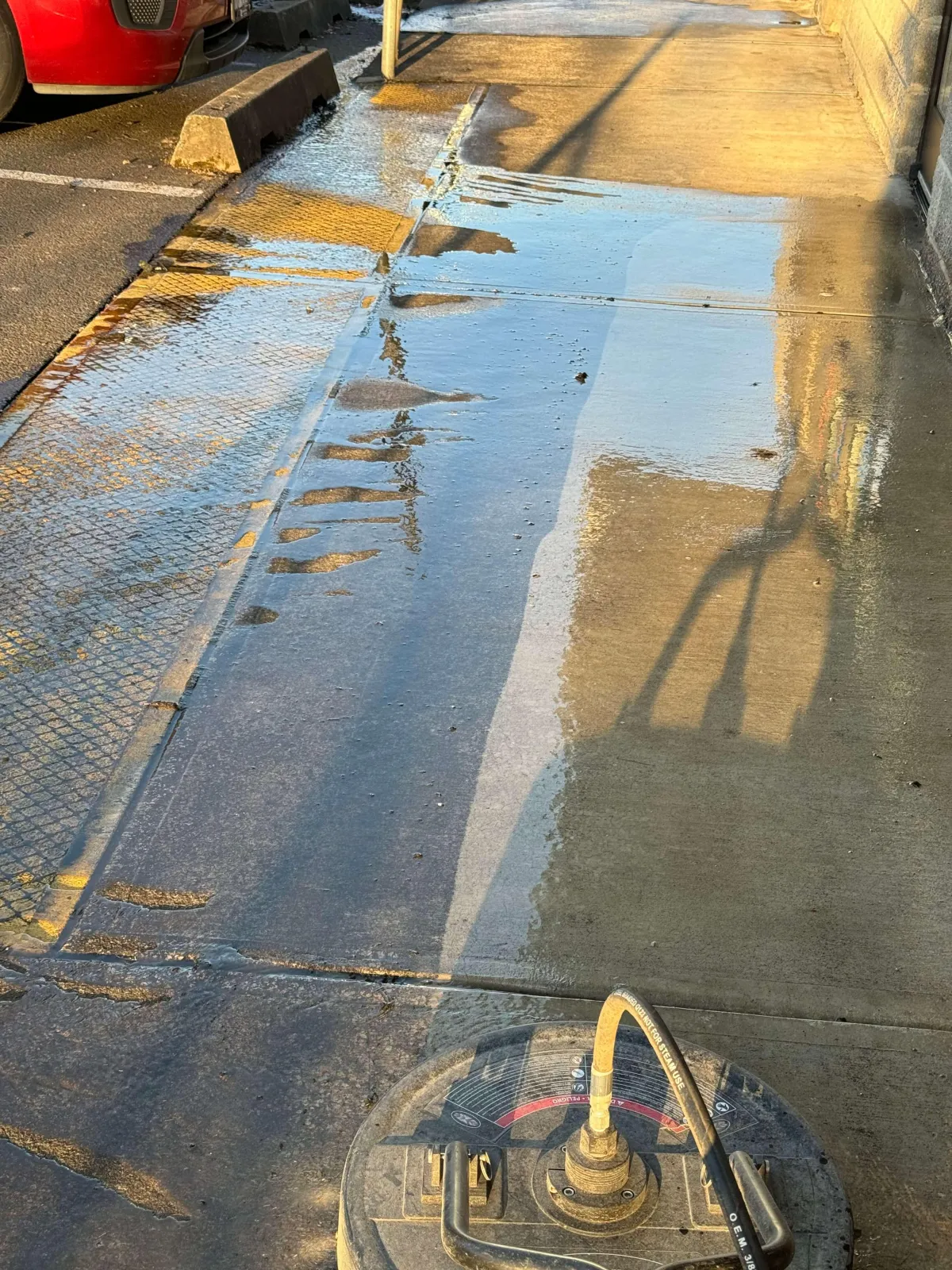 A surface cleaner showing the clear as day difference that pressure washing can make. The area the pressure washing hasn't happened it is a black color while the areas already pressure washed are a beautiful bright color.
