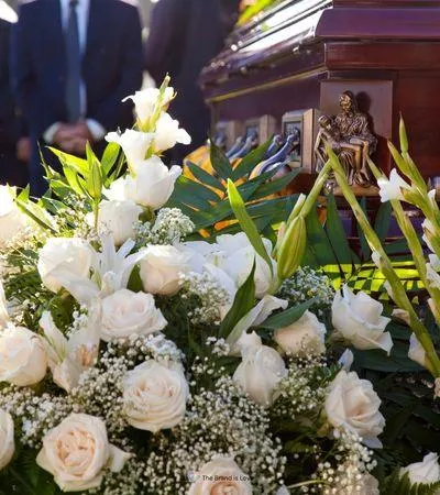 Casket with white flowers at a graveside service, showcasing how funeral pre-planning allows you to create a meaningful farewell.
